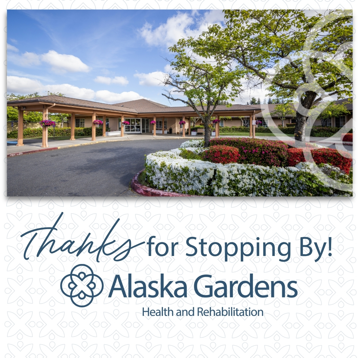 Entrance of Alaska Gardens Health and Rehabilitation facility with a porte-cochere and landscaped flower beds in front
